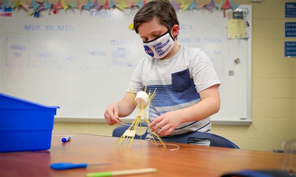 Boy adds to spaghetti tower